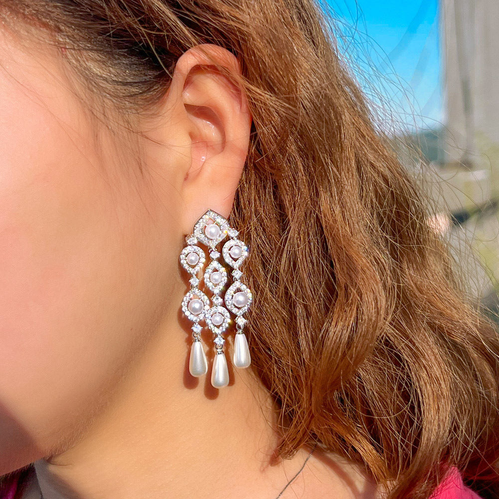 These earrings are accented with hand-picked sparkling Swarovski stones and Pearls. There are 14k white gold plated.
