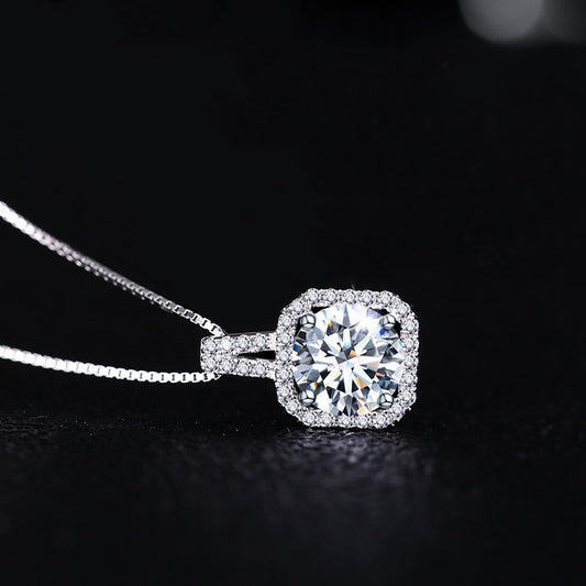 The round-cut stone is set in a delicate bezel with subtle studded detailing.