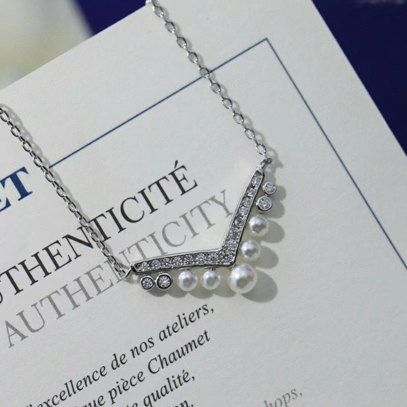 A refined V-shaped necklace inspired by the elegance of an aigrette plume.