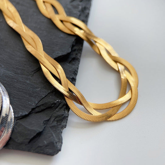 A matching set featuring an 18K gold herringbone bracelet and chain.