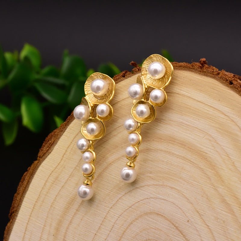 The nest-inspired setting adds texture and depth to the classic pearl, creating a refined and stylish accessory.