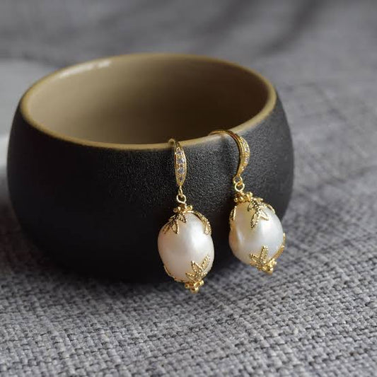 "Anti-tarnish pearl earrings with a polished finish."