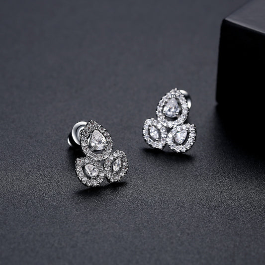 Silver tone pear-cut halo stud earrings in titanium steel with triple stone cluster design