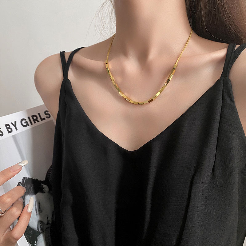 "Elevate your style with the sleek, refined beauty of an 18k gold bar necklace."