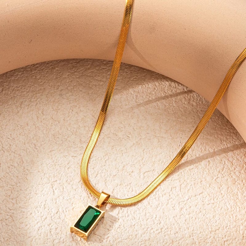 A stunning green emerald pendant set on a sleek herringbone chain made of durable titanium steel. 