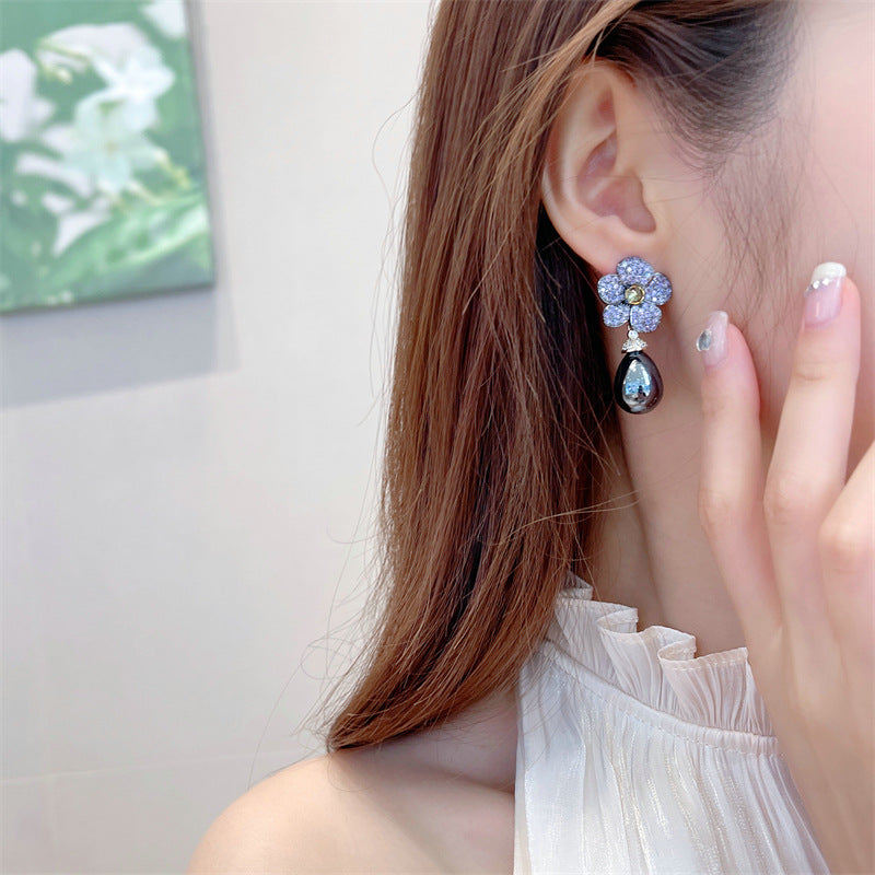 These earrings combine the beauty of a blooming flower with the brilliance of studded stones, creating a chic and feminine accessory."