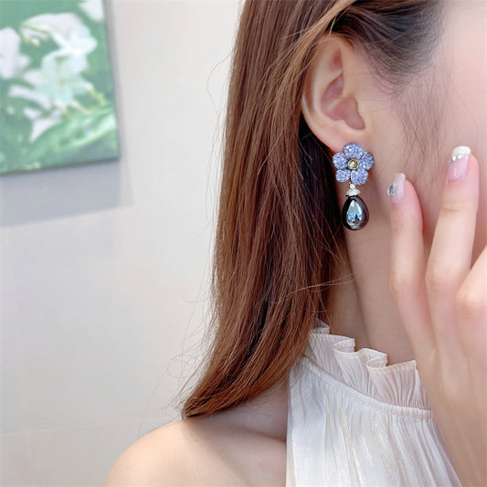 These earrings combine the beauty of a blooming flower with the brilliance of studded stones, creating a chic and feminine accessory."