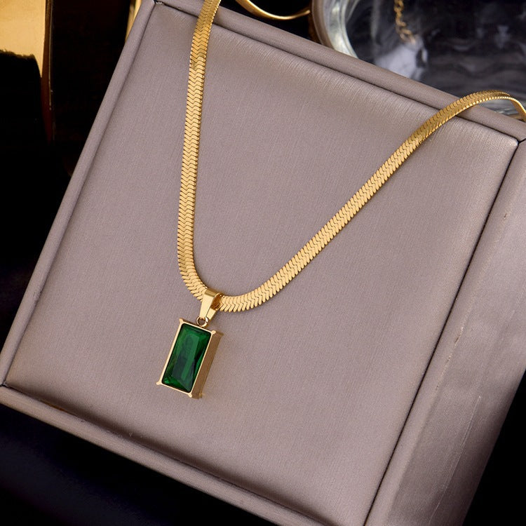 The emerald's vibrant color contrasts beautifully with the chain's smooth, polished surface. 