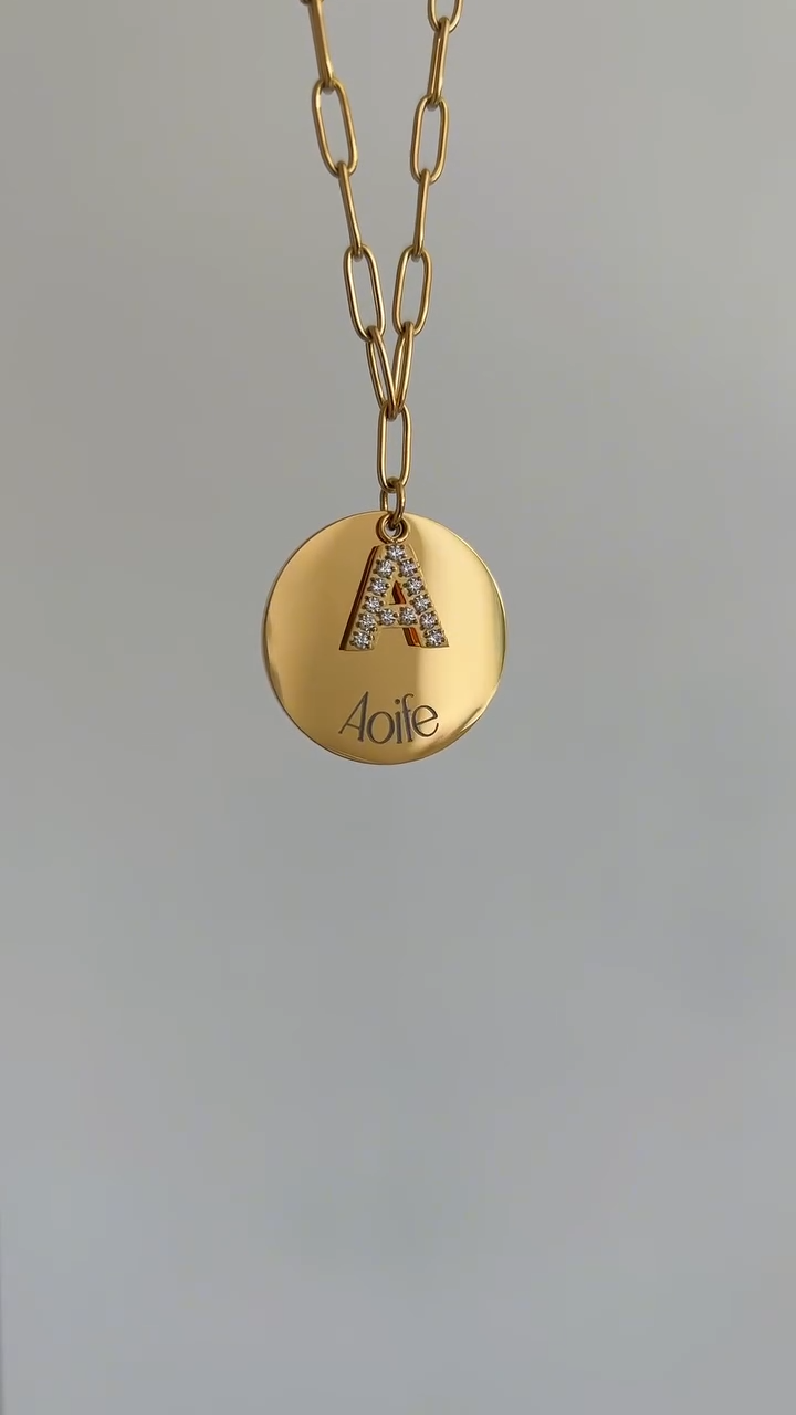Gold paperclip chain necklace with crystal-set initial and engraved round charm